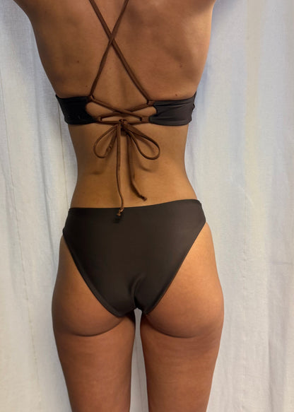 Ebba Bottom Chocolate är en chokladbrun bikinitrosa i briefmodell med normal midja och en något högre skärning framtill som ger ett visuellt intryck av längre ben. Underdelen är vändbar där ena sidan har en varmare brun ton med subtil lyster, medan den andra sidan är mörkbrun med sammetslen känsla. Bikiniunderdelen har medium täckning baktill. Stylad med Daniela Top, en  sportig bikinitopp med feminina detaljer och justerba snörning i ryggen. Svenska premium badkläder från Cocomoon Sweden.